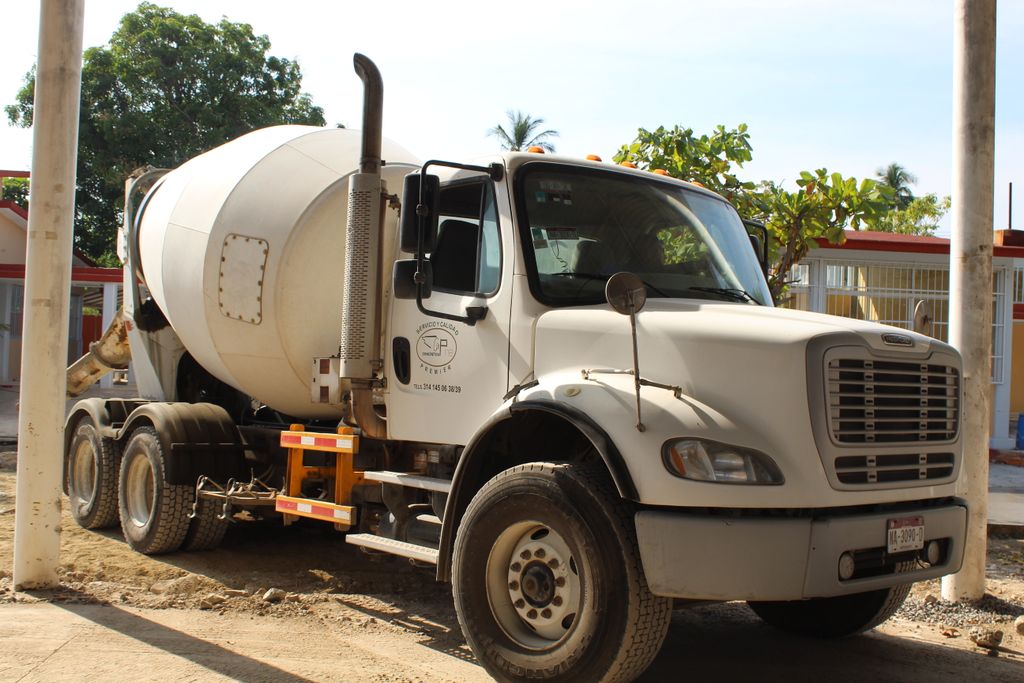 Colado de concreto premezclado durante día soleado en obra de Manzanillo, Colima, con trabajadores aplicando técnicas de control térmico